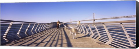 Framed Couple walking on a pier, Bay Bridge, San Francisco, California, USA Print