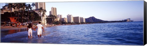 Framed Rear view of a couple wading on the beach, Waikiki Beach, Honolulu, Oahu, Hawaii, USA Print