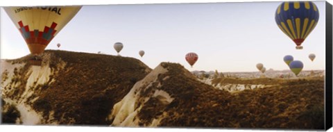 Framed Hot air balloons soaring over a mountain ridge, Cappadocia, Central Anatolia Region, Turkey Print