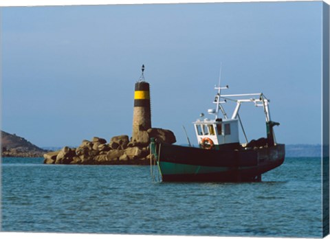 Framed Fishing trawler in front of a lighthouse at Port Saint-Sauveur, Ile Grande, Cotes-d&#39;Armor, Brittany, France Print