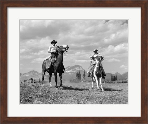 Framed Pair Of Cowboys On Horseback At Glacier Fifty Mountain Camp Print