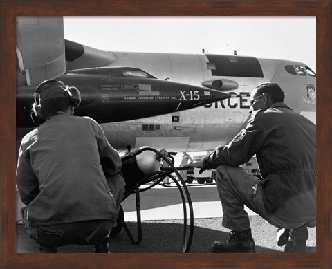 Framed Rear view of two men crouching near fighter planes, X-15 Rocket Research Airplane, B-52 Mothership Print