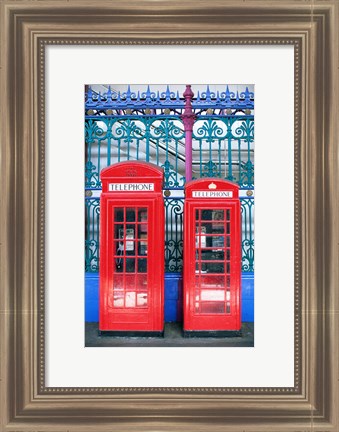 Framed Two telephone booths near a grille, London, England Print