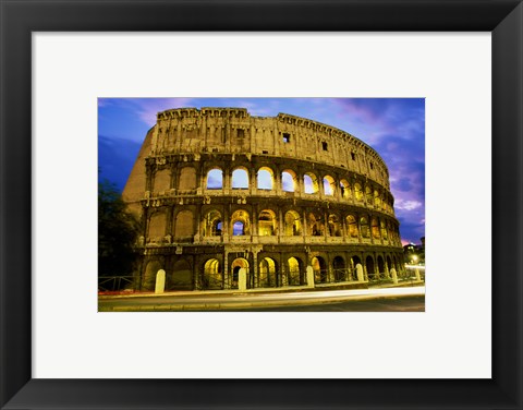 Framed Low angle view of the old ruins of an amphitheater lit up at dusk, Colosseum, Rome, Italy Print