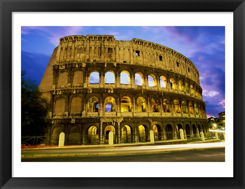 Framed Low angle view of the old ruins of an amphitheater lit up at dusk, Colosseum, Rome, Italy Print