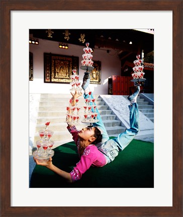 Framed Acrobat balancing glasses, Shanghai, China Print