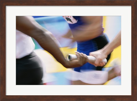 Framed Mid section view of runners exchanging baton at a relay race Print