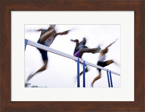 Framed Low angle view of three men jumping over a hurdle Print