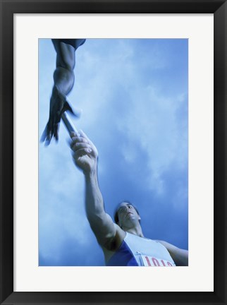 Framed Low angle view of runners passing a baton in a relay race Print