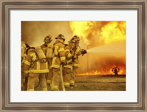 Framed Rear view of a group of firefighters extinguishing a fire Print