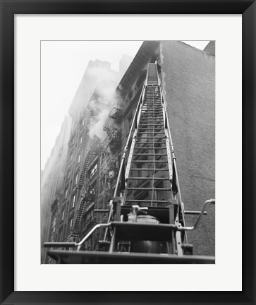 Framed Fire engine with ladder up burning building Print