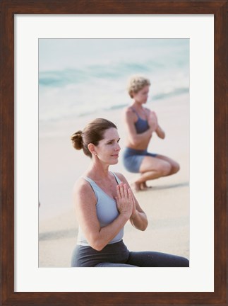 Framed Young woman and a mid adult woman meditating on the beach Print