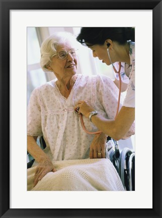 Framed Female nurse checking a female patient&#39;s heartbeat Print