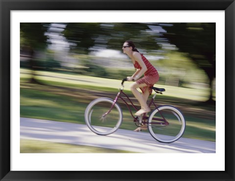 Framed Side profile of a young woman riding a bicycle Print