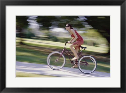 Framed Side profile of a young woman riding a bicycle Print