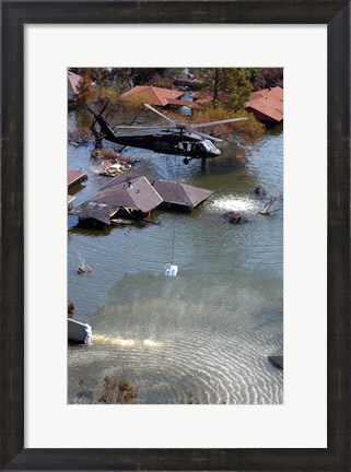 Framed Blackhawk helicopter drops sandbags into an area where the levee broke due to Hurricane Katrina Print