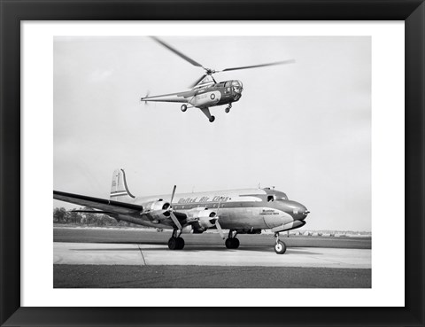 Framed Low angle view of a helicopter in flight and an airplane at an airport, Sikorsky Helicopter, Douglas DC-4 Print