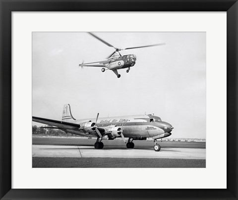 Framed Low angle view of a helicopter in flight and an airplane at an airport, Sikorsky Helicopter, Douglas DC-4 Print