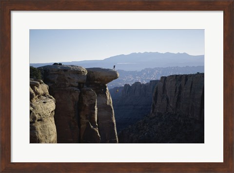 Framed Side profile of a young man pulling a young woman onto a rock Print