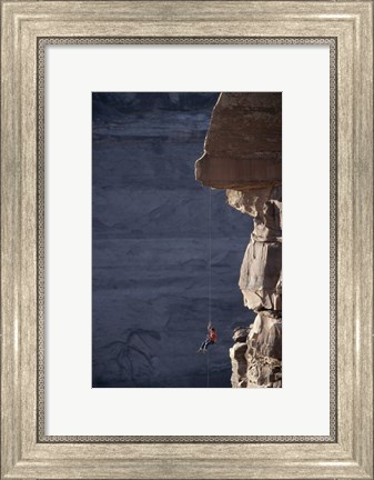 Framed Man hanging from a rope on the edge of a cliff Print