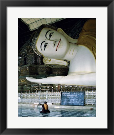 Framed Monk Sitting in Front of a Buddha Statue Print