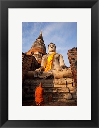 Framed Monk praying in front of a statue of Buddha Print