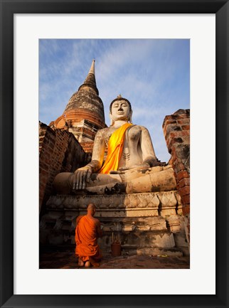 Framed Monk praying in front of a statue of Buddha Print