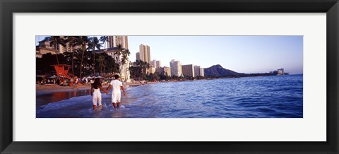 Framed Rear view of a couple wading on the beach, Waikiki Beach, Honolulu, Oahu, Hawaii, USA Print