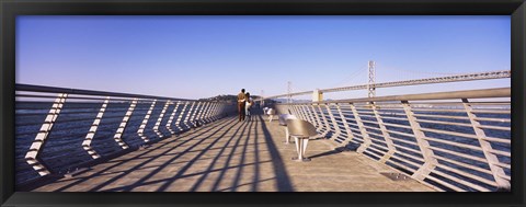 Framed Couple walking on a pier, Bay Bridge, San Francisco, California, USA Print