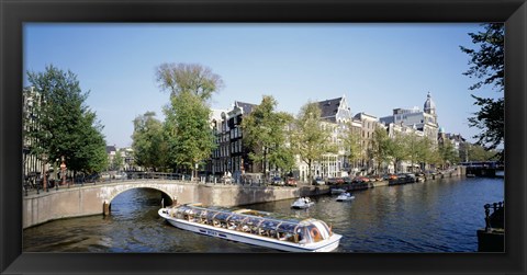 Framed Netherlands, Amsterdam, tour boat in channel Print