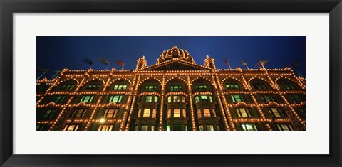 Framed Low angle view of a building lit up at night, Harrods, London, England Print