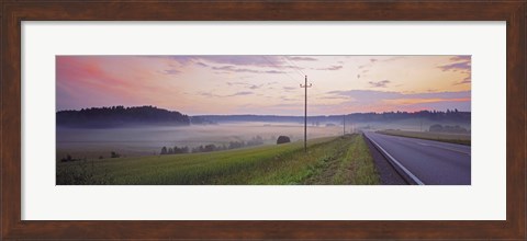 Framed Country road and telephone lines splitting farmlands at dawn, Finland Print