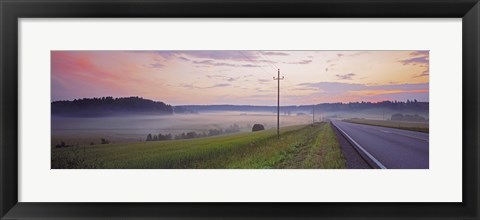 Framed Country road and telephone lines splitting farmlands at dawn, Finland Print