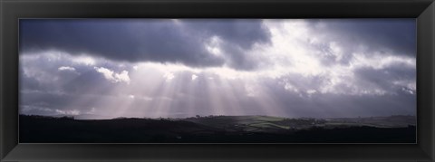 Framed Sunbeams radiating through dark clouds over rolling hills, Dartmoor, Devon, England Print