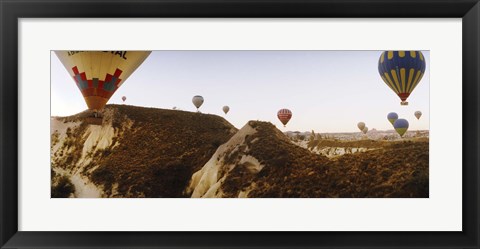 Framed Hot air balloons soaring over a mountain ridge, Cappadocia, Central Anatolia Region, Turkey Print