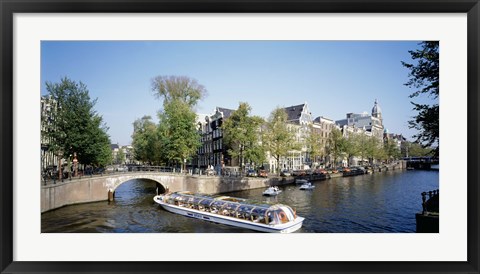 Framed Netherlands, Amsterdam, tour boat in channel Print