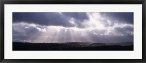 Framed Sunbeams radiating through dark clouds over rolling hills, Dartmoor, Devon, England Print