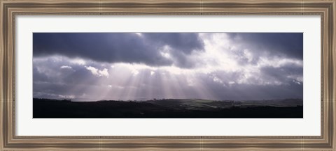 Framed Sunbeams radiating through dark clouds over rolling hills, Dartmoor, Devon, England Print