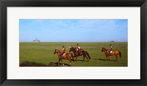 Framed Horseback riders in a field with Mont Saint-Michel island in background, Manche, Basse-Normandy, France Print