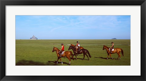 Framed Horseback riders in a field with Mont Saint-Michel island in background, Manche, Basse-Normandy, France Print