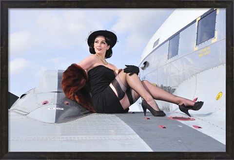 Framed Glamorous woman in 1940&#39;s style attire sitting on a vintage aircraft Print