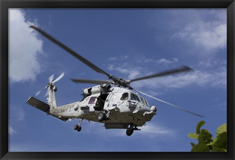 Framed Crew Chief looks out the side door of a helicopter in flight Print