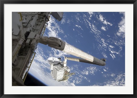 Framed Integrated Cargo Carrier in the grasp of the shuttle&#39;s remote manipulator system arm Print