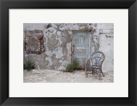 Framed Old Building chair and doorway in town of Oia, Santorini, Greece Print