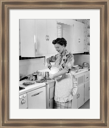 Framed 1950s Housewife In Kitchen Mixing Ingredients Print